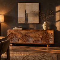 Sideboard with carved fan motifs across four panels and ball feet in a dark dining room at golden hour