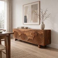 Sideboard with carved fan motifs across four panels and ball feet in a Scandinavian dining room with white walls