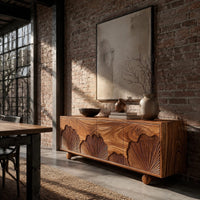 Sideboard with carved fan motifs across four panels and ball feet in an industrial loft dining room with exposed brick