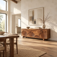Sideboard with carved fan motifs across four panels and ball feet in a bright open plan dining room