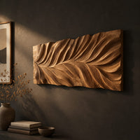 Wide wall art panel carved in a feather shaped leaf with sweeping ridges, three-quarter view showing the carved depth