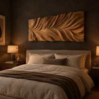 Wide wall art panel carved in a feather shaped leaf with sweeping ridges above a bed in a dusk lit bedroom