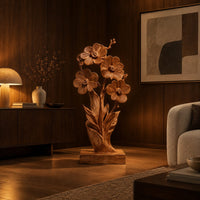 Carved wood flower sculpture with open blossoms and leaves on a block base in an evening living room with walnut wall paneling