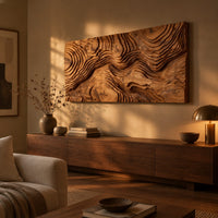 Wide wood relief wall art carved with flowing contour ridges above a low console in an evening living room