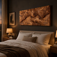 Wide wood relief wall art carved with flowing contour ridges above a bed in a dusk lit bedroom