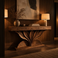 Console table with a carved leaf fan base and three drawer fronts in an evening entryway with walnut wall paneling