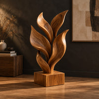 Sculpture of smooth carved leaves rising from a square block base, three-quarter view showing the grain
