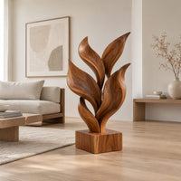 Sculpture of smooth carved leaves rising from a square block base in a Scandinavian living room with white walls
