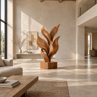 Sculpture of smooth carved leaves rising from a square block base in a bright open plan living room