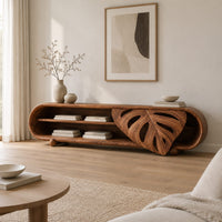 Capsule shaped tv stand with open shelves and a carved leaf panel in a Scandinavian living room with white walls