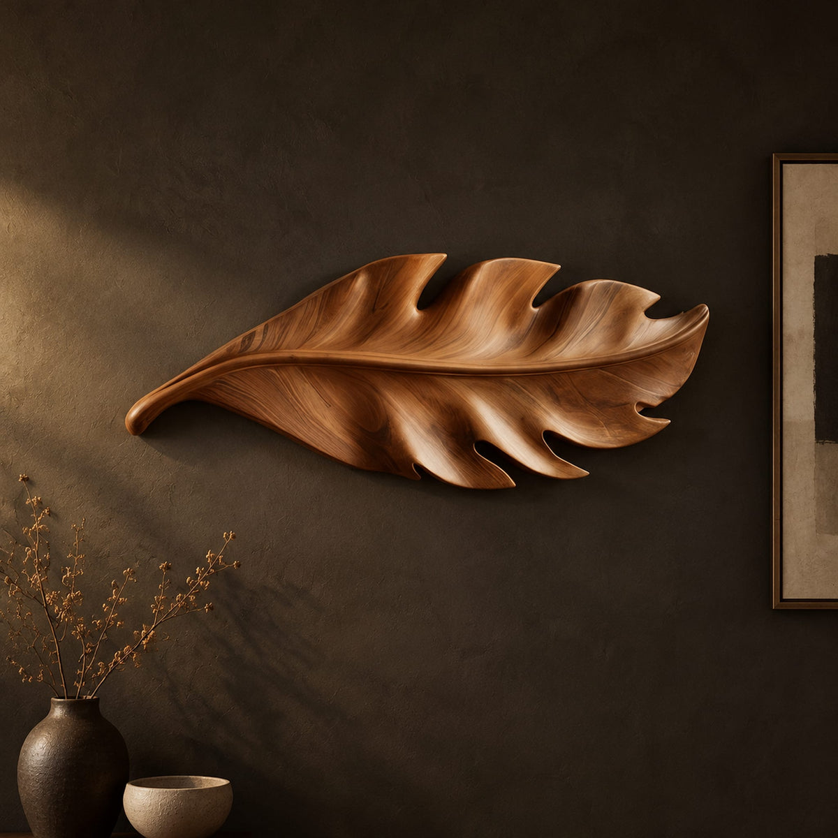 Leaf shaped wall art in wood with notched lobes and carved veins on a dark charcoal plaster wall