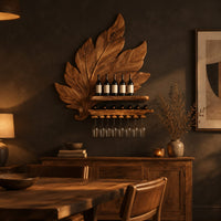 Carved leaf wine rack with a bottle ledge and glass hangers in a dark dining room at golden hour