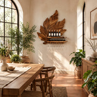 Carved leaf wine rack with a bottle ledge and glass hangers in a bright dining room with arched windows and plants