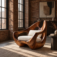 Carved lounge chair with a deep wooden shell and open oval cutouts in an industrial loft living room with exposed brick