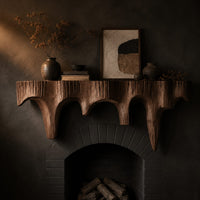 Corner detail of mantel shelf with tapered drip arches and a rough grooved face beside wood, brass and linen samples