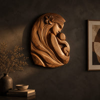Wall art carved as a mother holding her child, with long flowing hair on a dark charcoal plaster wall