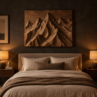 Wood wall art with carved mountain peaks in deep relief above a bed in a dusk lit bedroom
