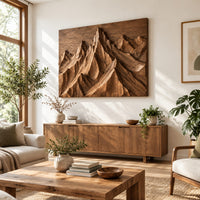 Wood wall art with carved mountain peaks in deep relief in a bright sunroom with green plants