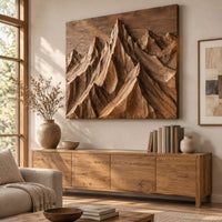 Wood wall art with carved mountain peaks in deep relief above a light oak sideboard in daylight