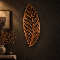 Carved openwork leaf wall art with flowing veins on a dark charcoal plaster wall