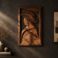 Carved wall art of a profile in a wide brim hat on a dark charcoal plaster wall