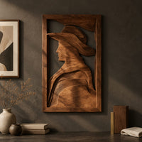 Detail of carved wall art of a profile in a wide brim hat beside wood, brass and linen samples