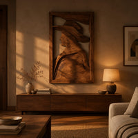 Carved wall art of a profile in a wide brim hat above a low console in an evening living room
