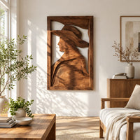 Carved wall art of a profile in a wide brim hat in a bright sunroom with green plants