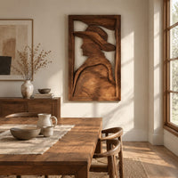 Carved wall art of a profile in a wide brim hat beside a dining table in natural light