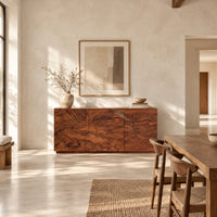 Sideboard with a carved sunrise and rolling waves across three doors in a bright open plan dining room