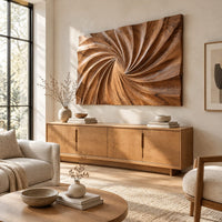 Wall art panel with a swirling carved ridge pattern radiating from the center above a light oak sideboard in daylight