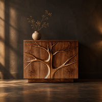 Two door sideboard with a carved tree branch relief across the fronts in a dark dining room at golden hour