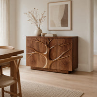 Two door sideboard with a carved tree branch relief across the fronts in a Scandinavian dining room with white walls