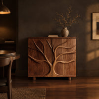 Two door sideboard with a carved tree branch relief in a dark dining room at golden hour