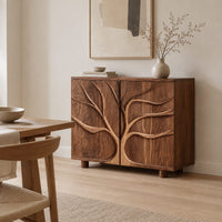 Two door sideboard with a carved tree branch relief in a Scandinavian dining room with white walls