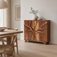 Two door sideboard with a carved tree branch relief across the doors in a Scandinavian dining room with white walls