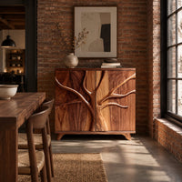 Two door sideboard with a carved tree branch relief across the doors in an industrial loft dining room with exposed brick