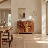 Two door sideboard with a carved tree branch relief across the doors in a bright open plan dining room