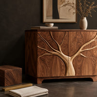 Corner detail of two door sideboard with a tree carved in relief across both doors beside wood, brass and linen samples