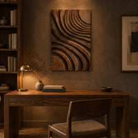 Carved wooden wall panel with sweeping layered grooves above a desk in a dark study corner
