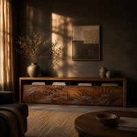 Long tv stand with four carved doors showing ocean waves and a rising sun in a dark living room at golden hour