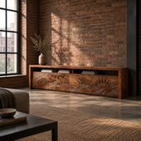 Long tv stand with four carved doors showing ocean waves and a rising sun in an industrial loft living room with exposed brick