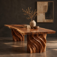 Corner detail of dining table with a natural edge slab top and two carved wave pedestals beside wood, brass and linen samples
