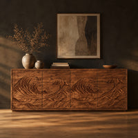 Sideboard with four doors carved in a rolling ocean wave relief in a dark studio against a charcoal plaster wall