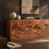 Corner detail of sideboard with four doors carved in a rolling ocean wave relief beside wood, brass and linen samples