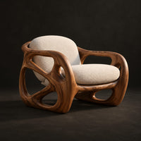 Chair with a chunky sculpted frame, large oval cutouts and a pillow back, three-quarter view showing the grain