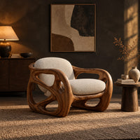 Chair with a chunky sculpted frame, large oval cutouts and a pillow back in a dark living room at golden hour