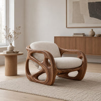 Chair with a chunky sculpted frame, large oval cutouts and a pillow back in a Scandinavian living room with white walls