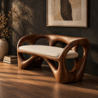 Bench with a looped wooden frame, cutout back and cream cushion, three-quarter view showing the grain