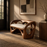 Bench with a looped wooden frame, cutout back and cream cushion in an industrial loft entryway with exposed brick
